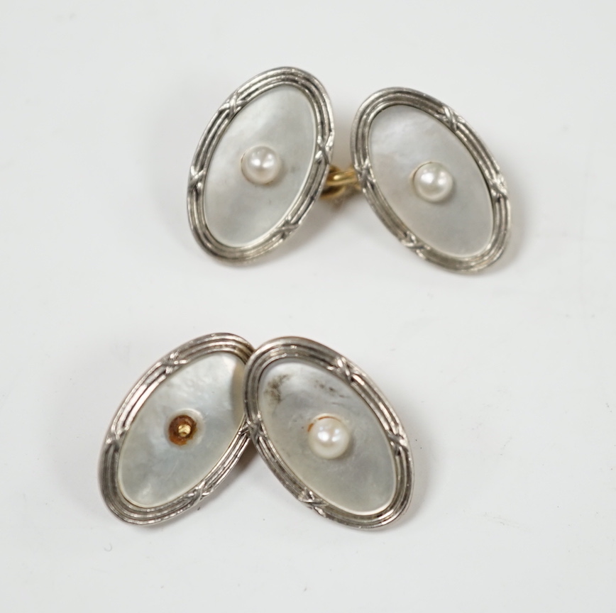 A pair of Edwardian 15ct, mother of pearl and seed pearl set oval cufflinks, 17mm, gross weight 7.3 grams.